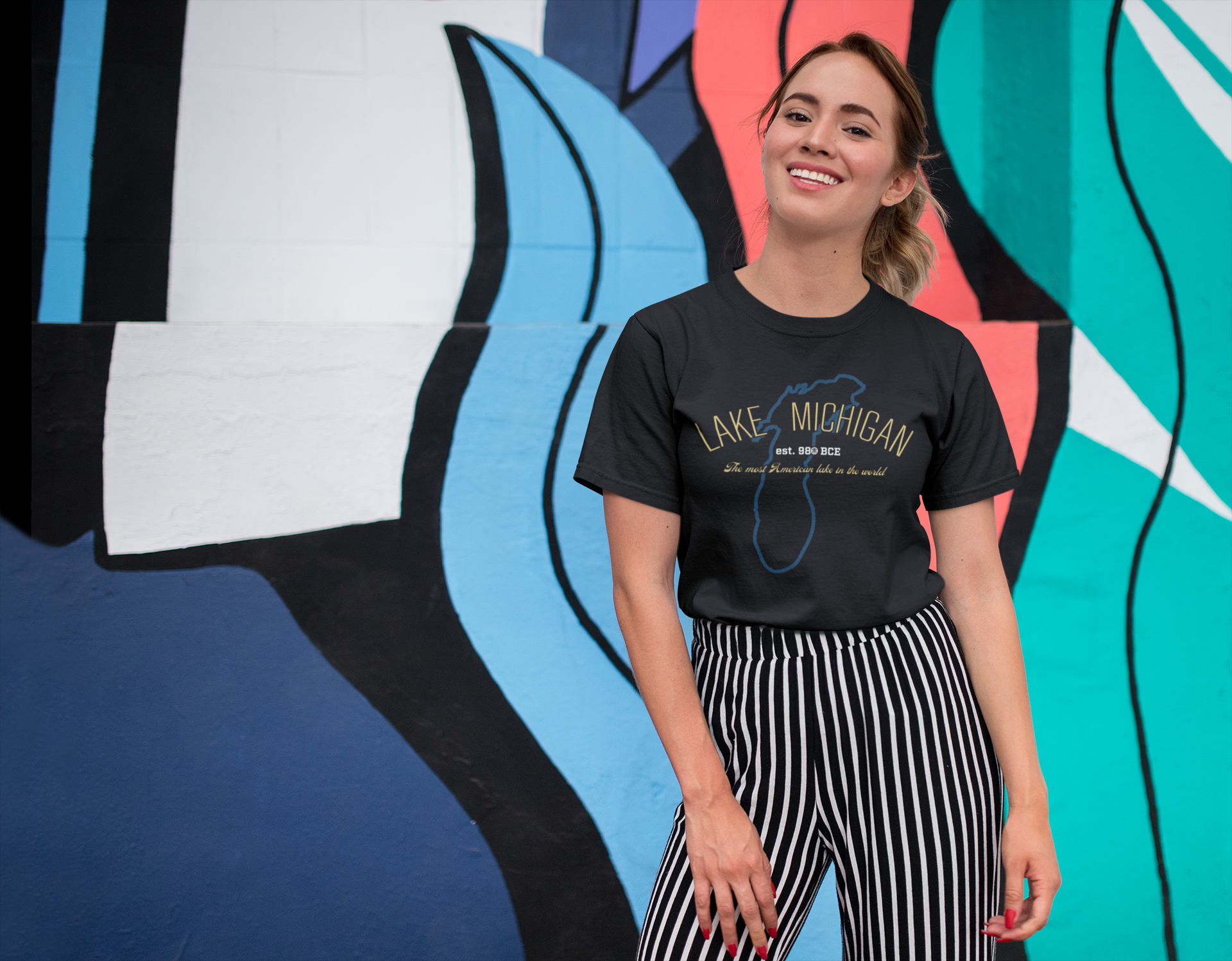 Girl wearing Lake Michigan shirt in front of mural